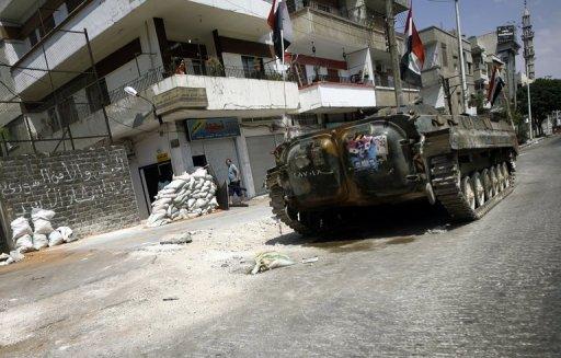 Photographe : Joseph Eid, AFP : Un char prend position dans une rue d'Oms, le 30 août 2011